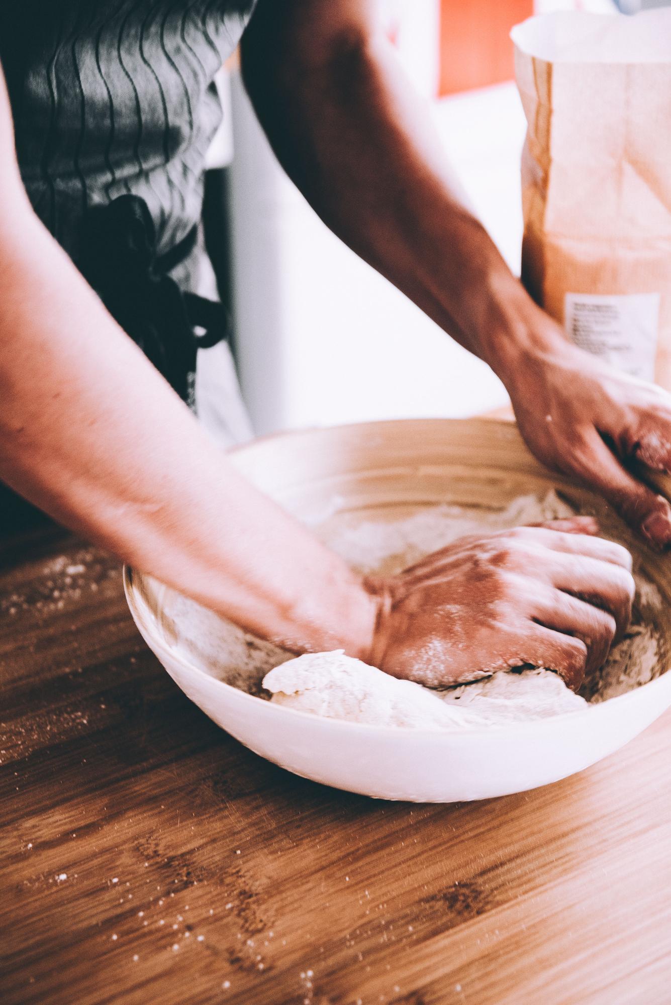 closeup hands preparing dough on counter