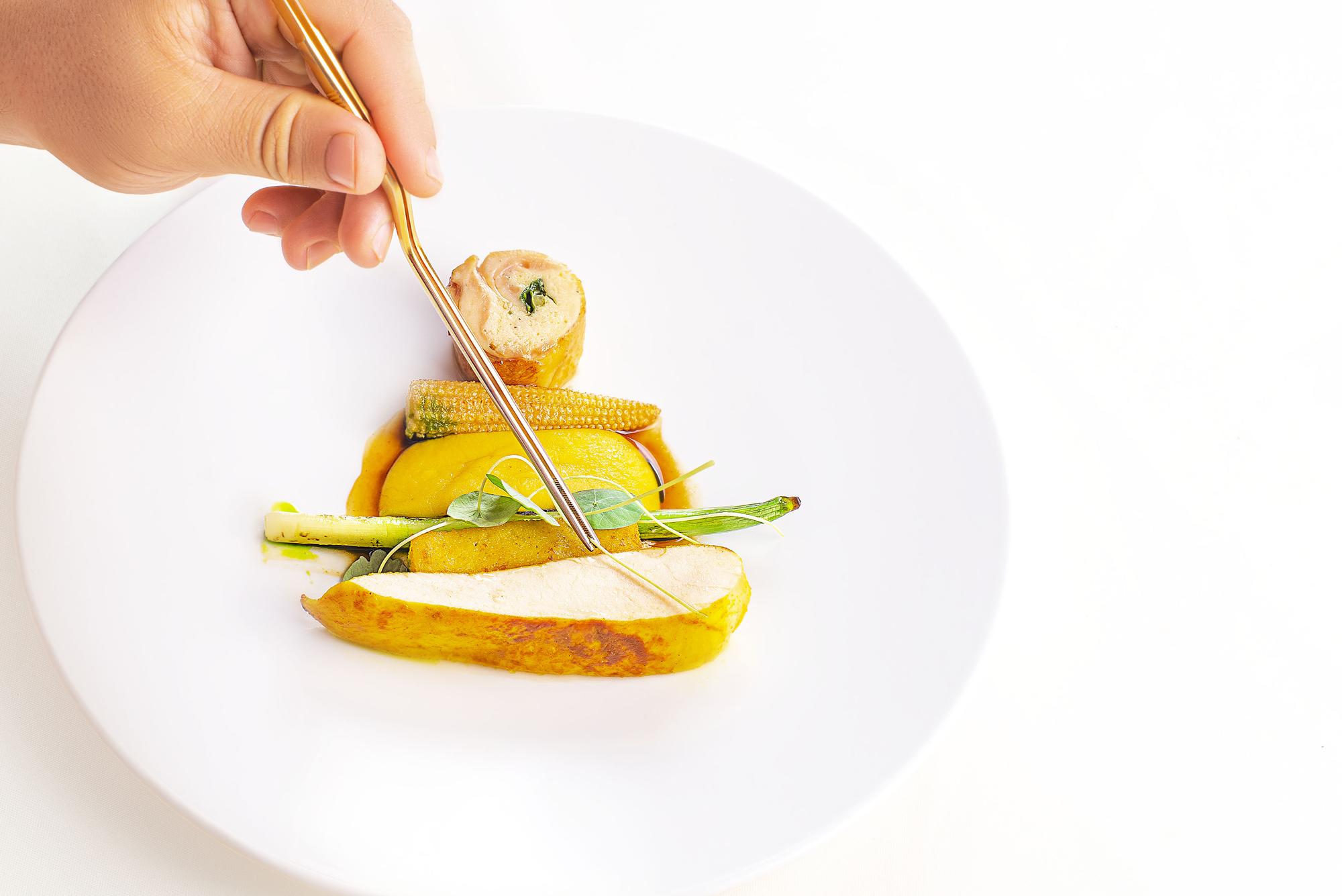 chef plating colorful dish in studio kitchen